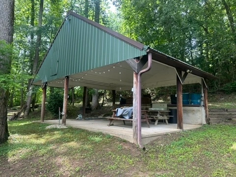 Group arbor with power, lighting, and seating at River's Edge Primitive Camping